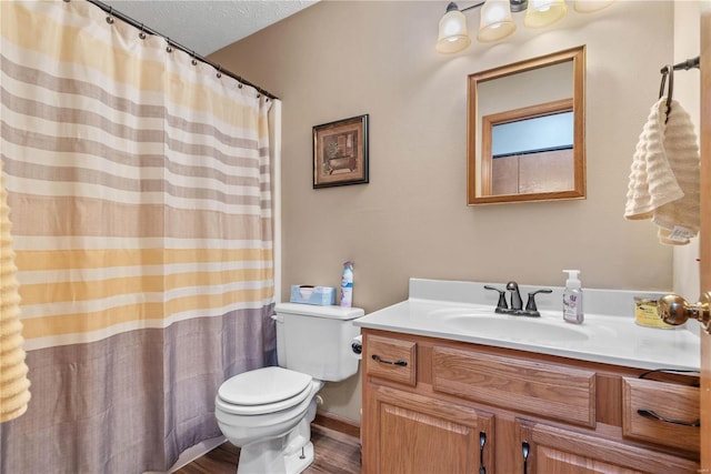 bathroom with vanity, wood-type flooring, toilet, and a textured ceiling