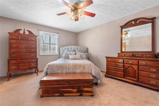 carpeted bedroom featuring a textured ceiling and ceiling fan