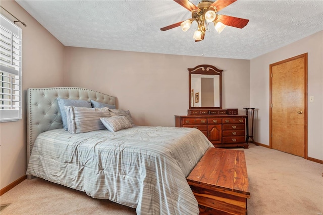 carpeted bedroom featuring ceiling fan and a textured ceiling