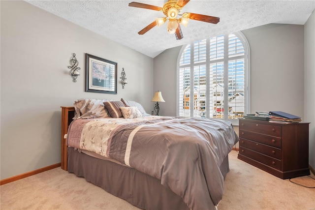 carpeted bedroom featuring ceiling fan, vaulted ceiling, and a textured ceiling