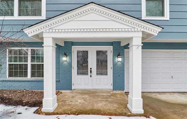 property entrance featuring a garage and french doors