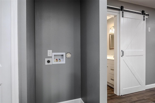 laundry area featuring electric dryer hookup, hookup for a washing machine, dark hardwood / wood-style floors, and a barn door