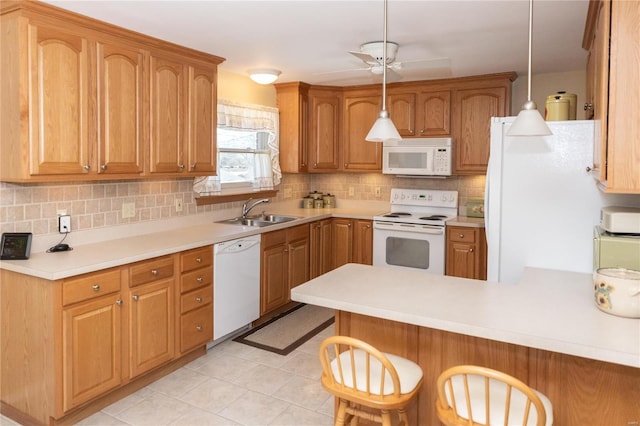 kitchen featuring sink, kitchen peninsula, white appliances, and decorative light fixtures