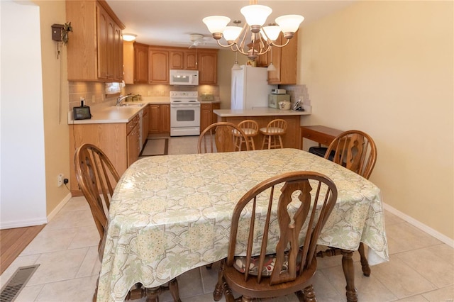 dining area featuring sink, a notable chandelier, and light tile patterned flooring