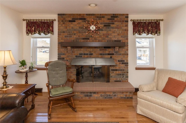 living room featuring hardwood / wood-style floors and a brick fireplace