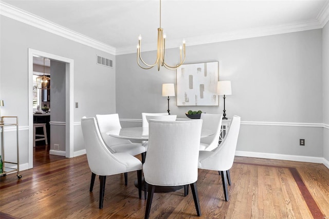 dining space with a chandelier, visible vents, ornamental molding, and wood finished floors