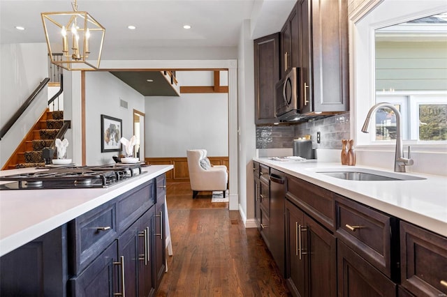 kitchen featuring dark wood-type flooring, appliances with stainless steel finishes, light countertops, and a sink