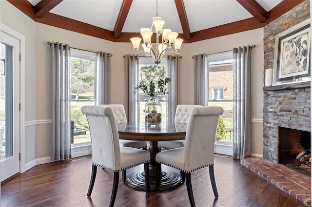 dining area featuring a fireplace, baseboards, beam ceiling, dark wood-style floors, and an inviting chandelier