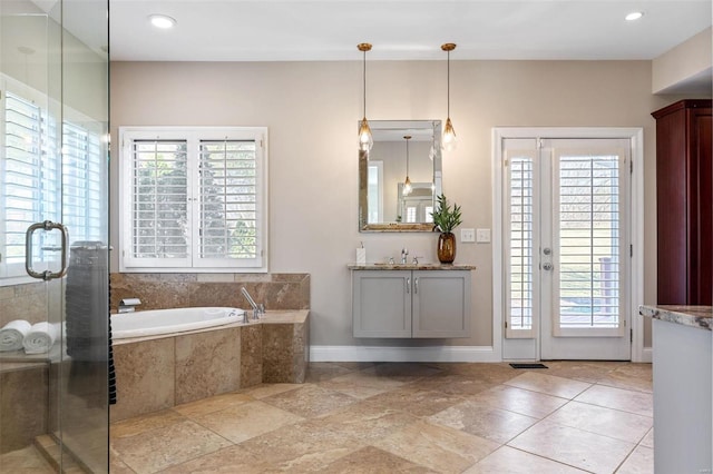 full bathroom featuring recessed lighting, vanity, baseboards, a bath, and a stall shower