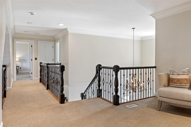 hallway with carpet flooring, visible vents, crown molding, and an upstairs landing