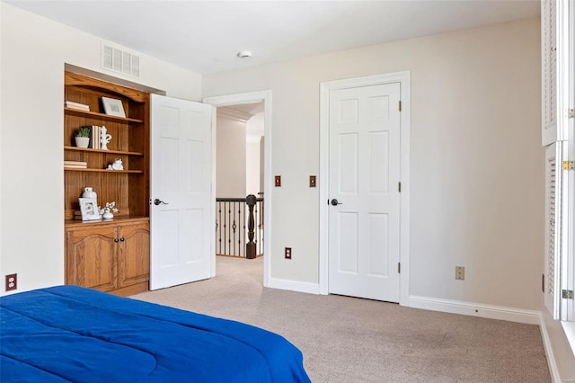 carpeted bedroom featuring baseboards and visible vents