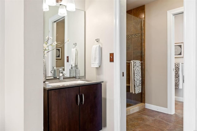 full bath with a stall shower, vanity, and baseboards