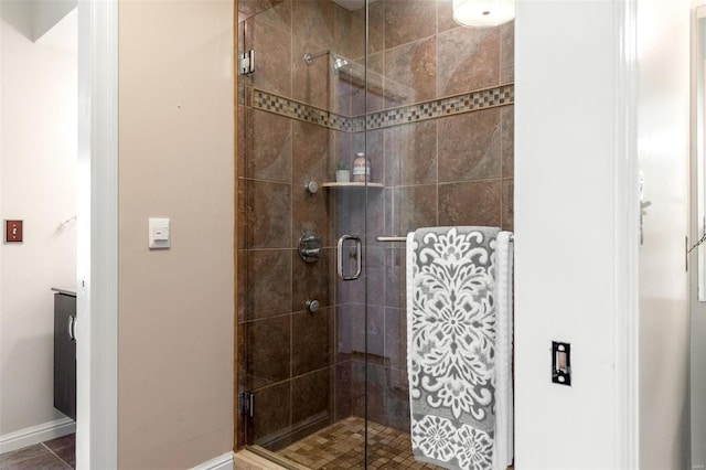 bathroom with a stall shower and baseboards