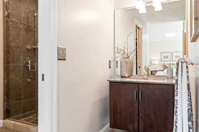 bathroom with baseboards, a shower stall, and vanity