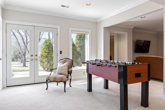 game room featuring ornamental molding, french doors, a healthy amount of sunlight, and light carpet