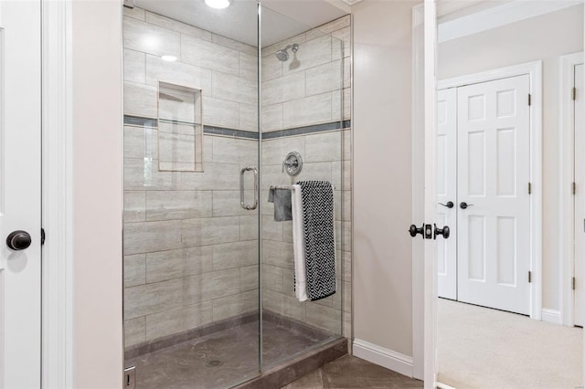 bathroom featuring a stall shower and baseboards