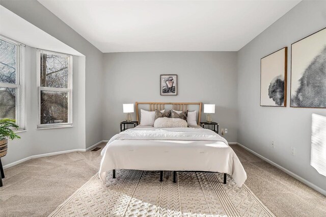 bedroom with light carpet and baseboards