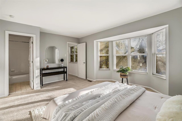 bedroom featuring carpet, connected bathroom, visible vents, and baseboards