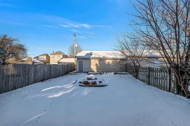 yard layered in snow featuring a fenced backyard