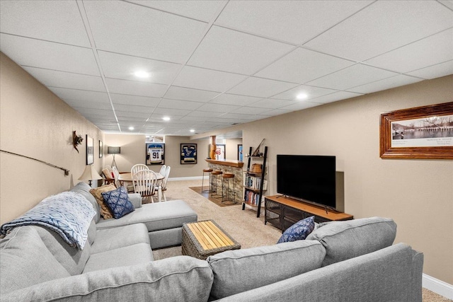 carpeted living room featuring a paneled ceiling