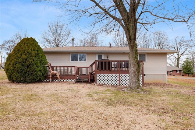 rear view of property with a wooden deck and a yard