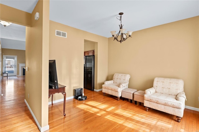 sitting room featuring a chandelier and light wood-type flooring