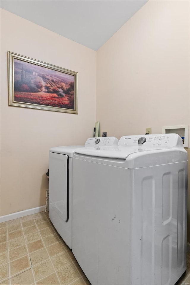 laundry area featuring washing machine and dryer and light tile patterned flooring