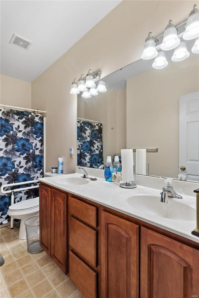 bathroom featuring vanity, tile patterned floors, and toilet