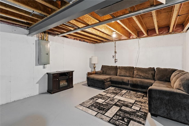 living room with concrete flooring, a wood stove, and electric panel