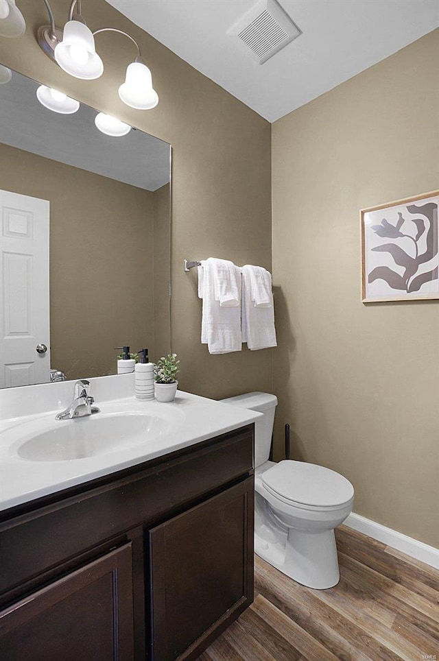 bathroom with vanity, toilet, a chandelier, and wood-type flooring