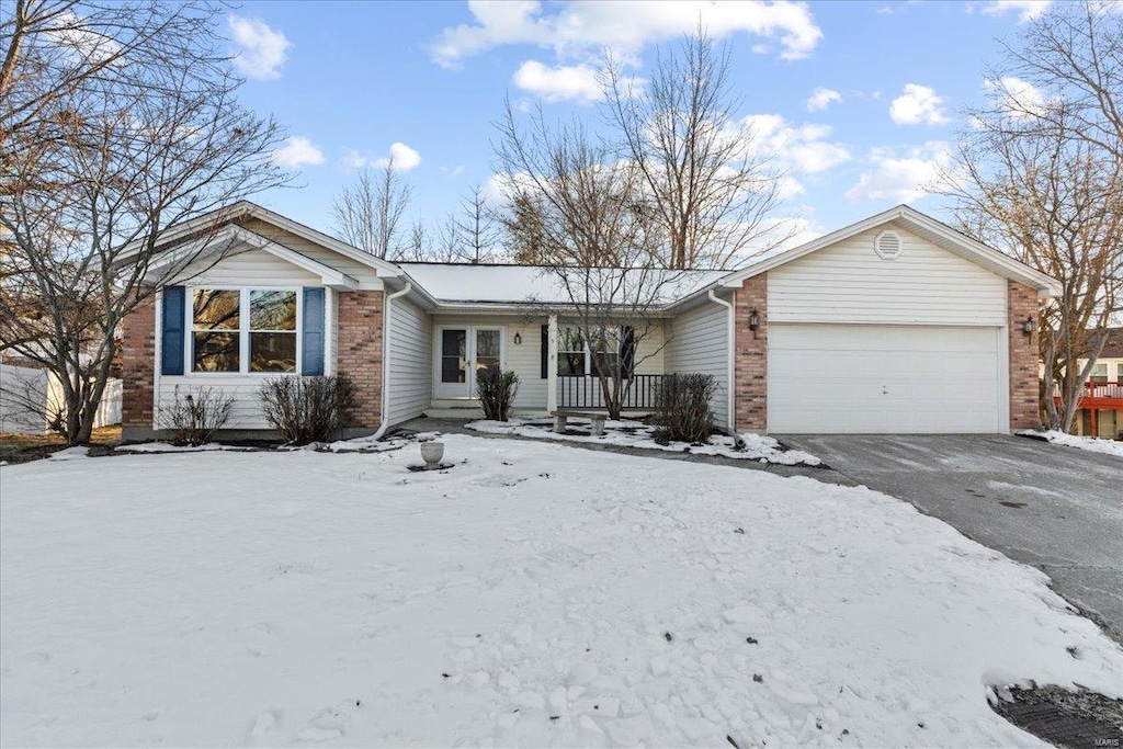 single story home featuring a garage and a porch