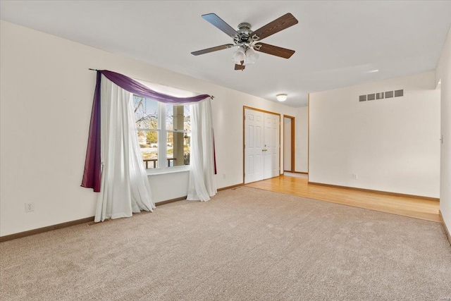 carpeted spare room with ceiling fan