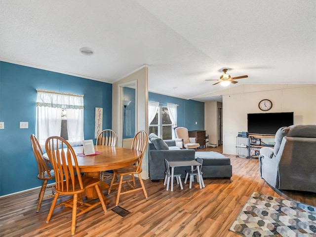 dining area with lofted ceiling, plenty of natural light, hardwood / wood-style floors, and a textured ceiling