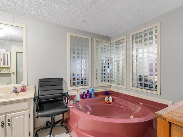 bathroom featuring a tub to relax in, vanity, and a textured ceiling