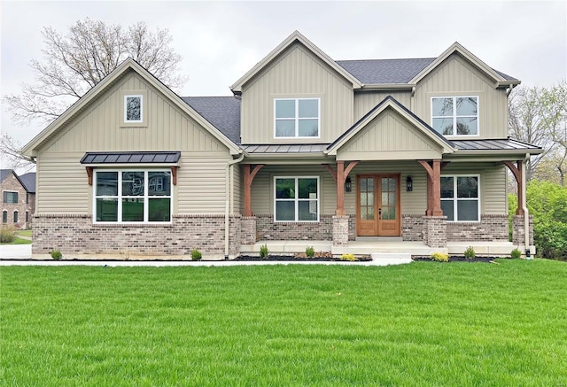 craftsman inspired home featuring a standing seam roof, covered porch, metal roof, and brick siding