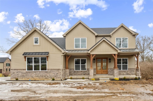 craftsman house featuring brick siding, covered porch, metal roof, and a standing seam roof