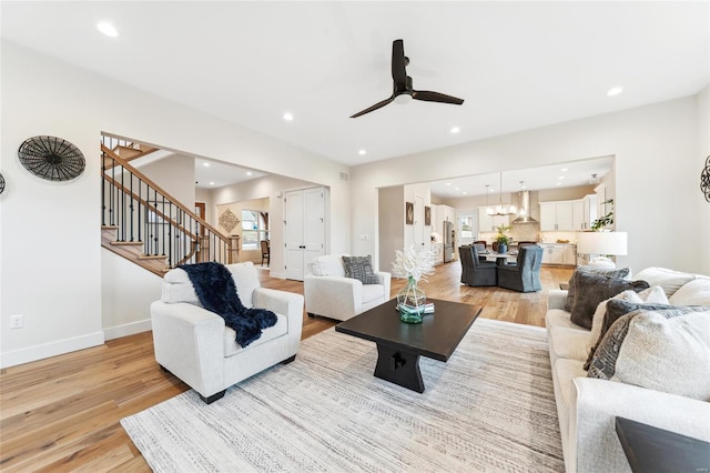 living room with light wood-style flooring, recessed lighting, and stairway