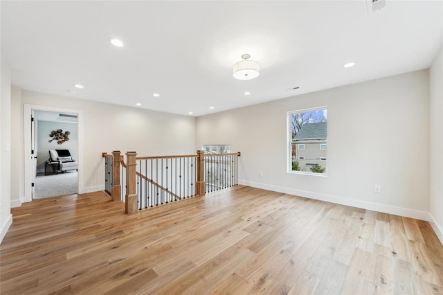 spare room featuring baseboards, light wood finished floors, and recessed lighting