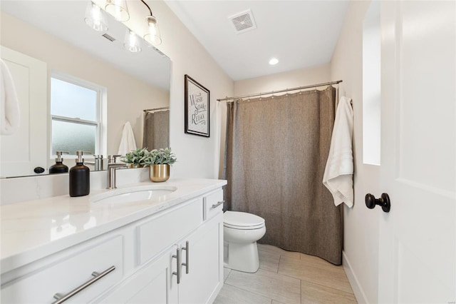 bathroom with vanity, visible vents, and toilet
