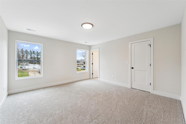 spare room with visible vents, baseboards, and carpet flooring