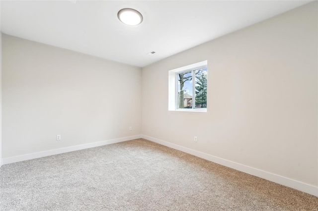 carpeted spare room featuring baseboards