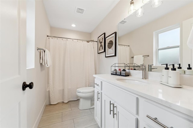 full bathroom featuring vanity, visible vents, baseboards, and toilet