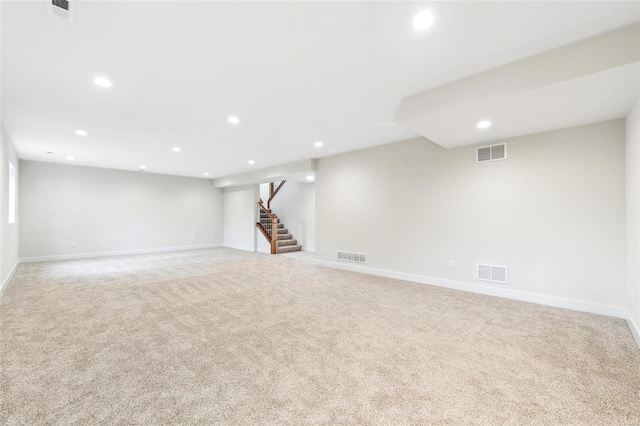 finished basement featuring visible vents, recessed lighting, and light colored carpet