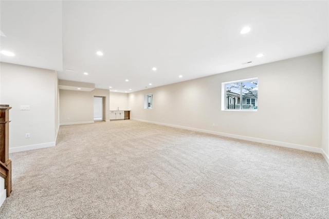 below grade area with light carpet, baseboards, and recessed lighting