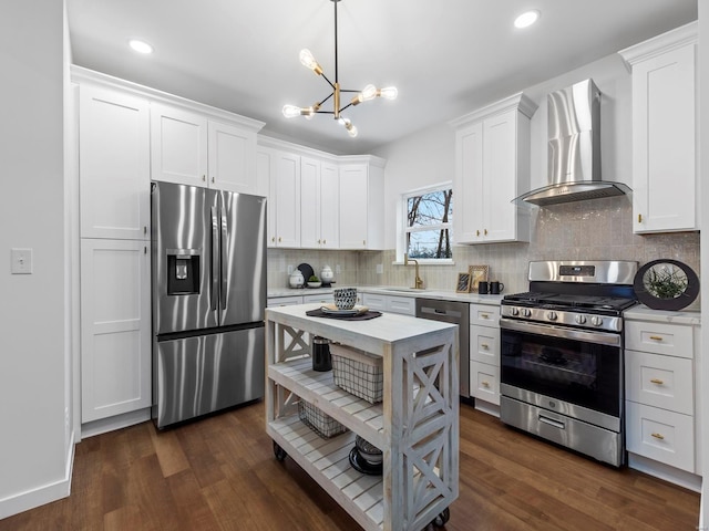 kitchen featuring white cabinets, stainless steel appliances, sink, and wall chimney range hood