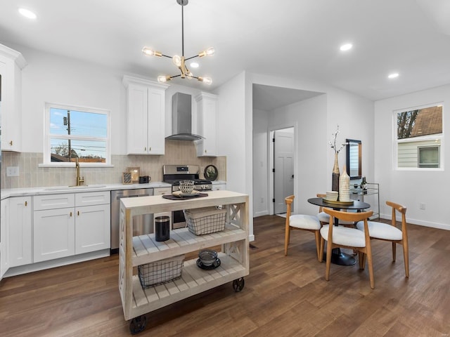 kitchen with white cabinetry, wall chimney range hood, stainless steel appliances, and sink