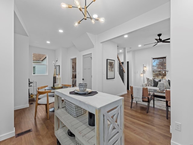 kitchen with hardwood / wood-style floors and ceiling fan with notable chandelier
