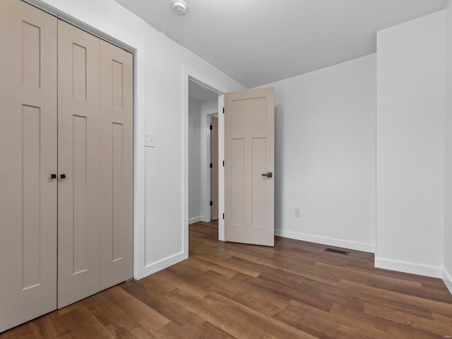 unfurnished bedroom with hardwood / wood-style flooring and a closet