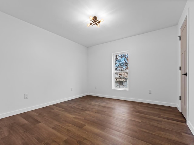 spare room with dark wood-type flooring
