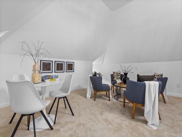 dining space with vaulted ceiling and light carpet